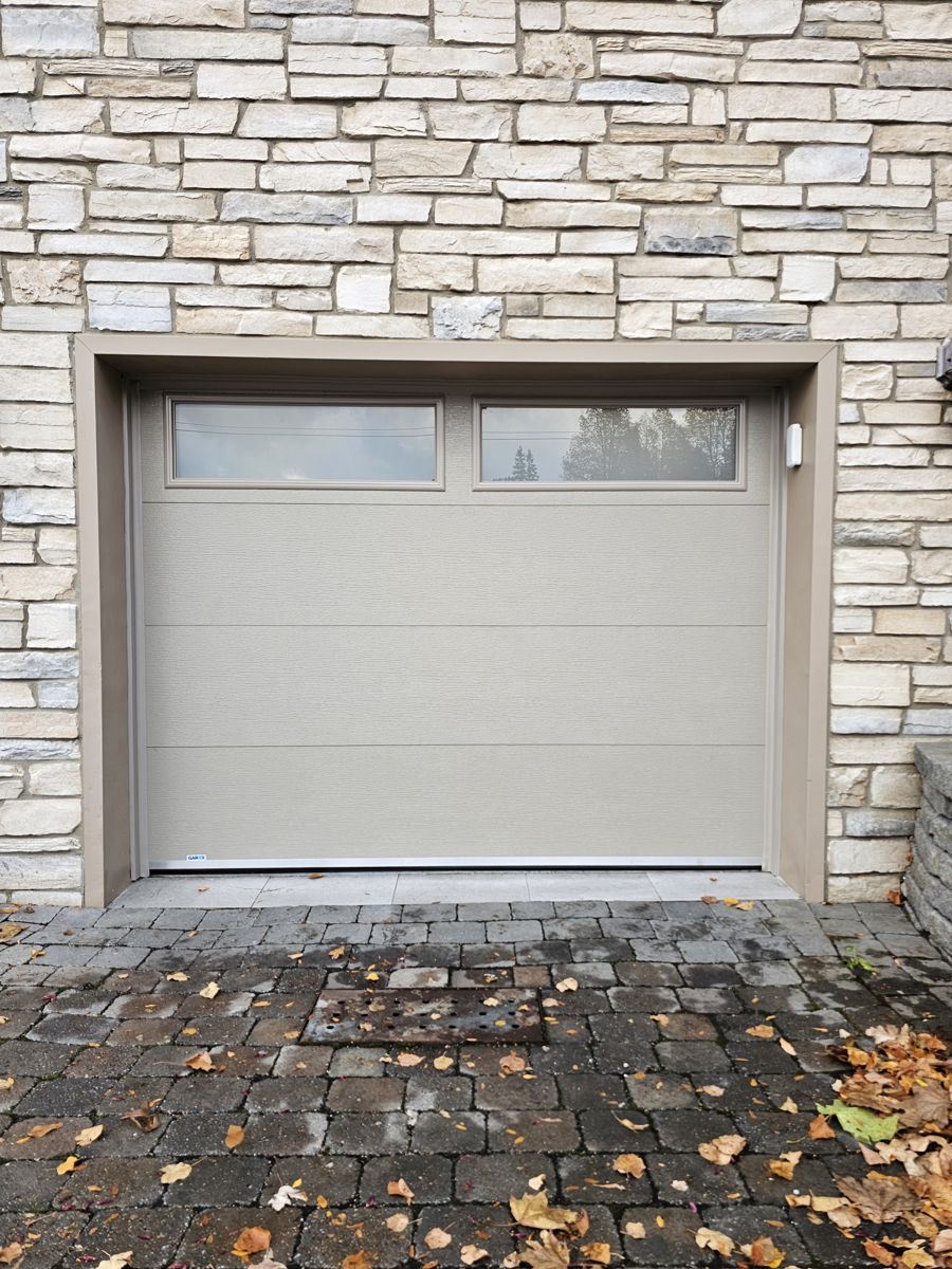 Porte de garage résidentielle beige avec fenêtres